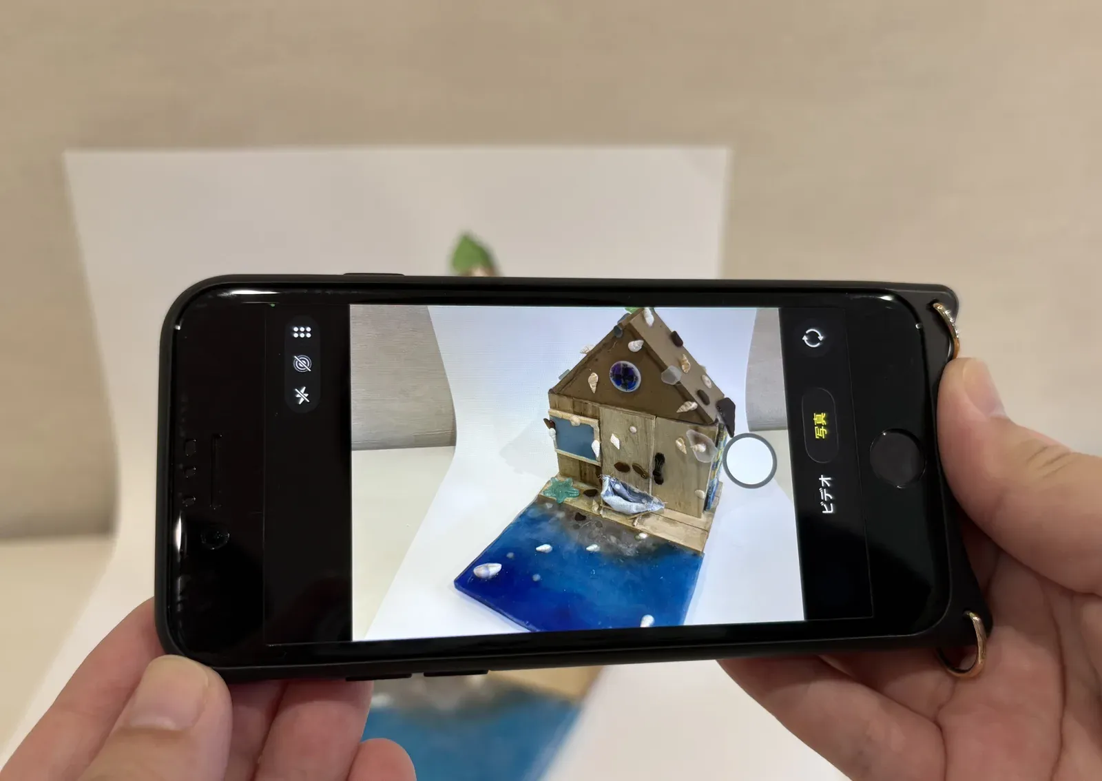 白い紙を背景に、窓際の自然光で工作を撮影している手元