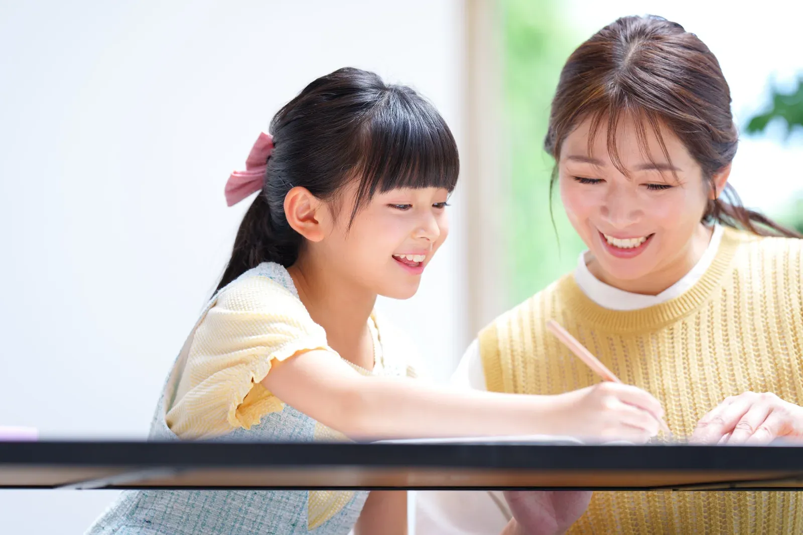 描いた絵を前に、横並びで笑いながら話している親子