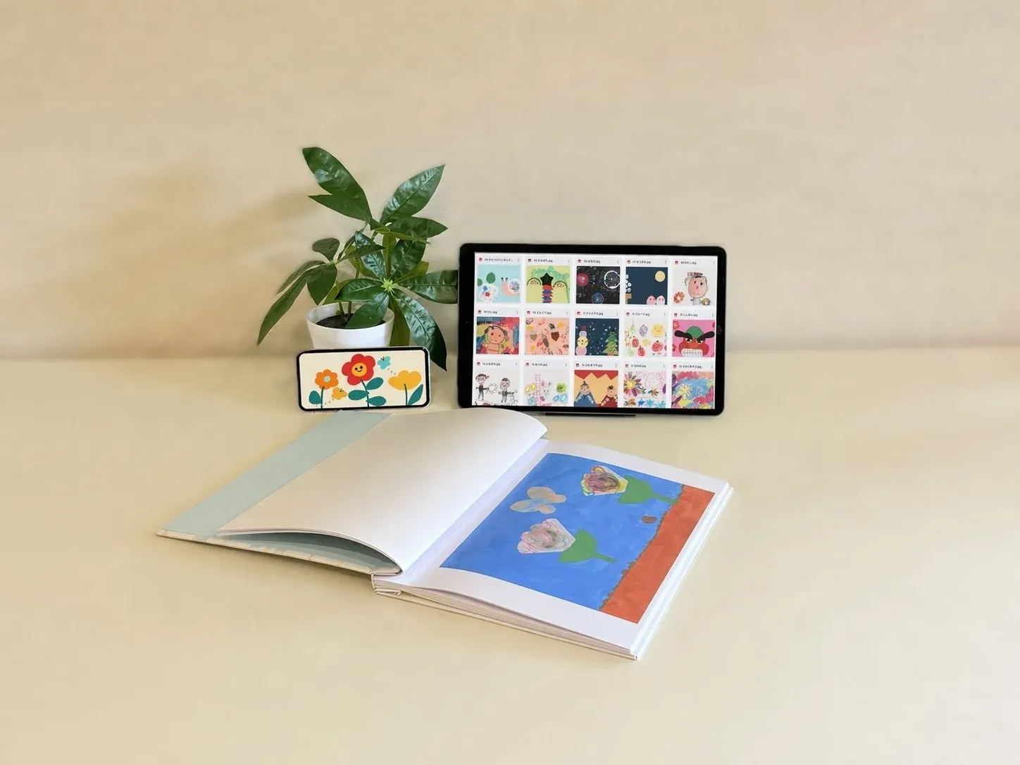 データ化した子どもの作品を、タブレットとスマホで見ているところ