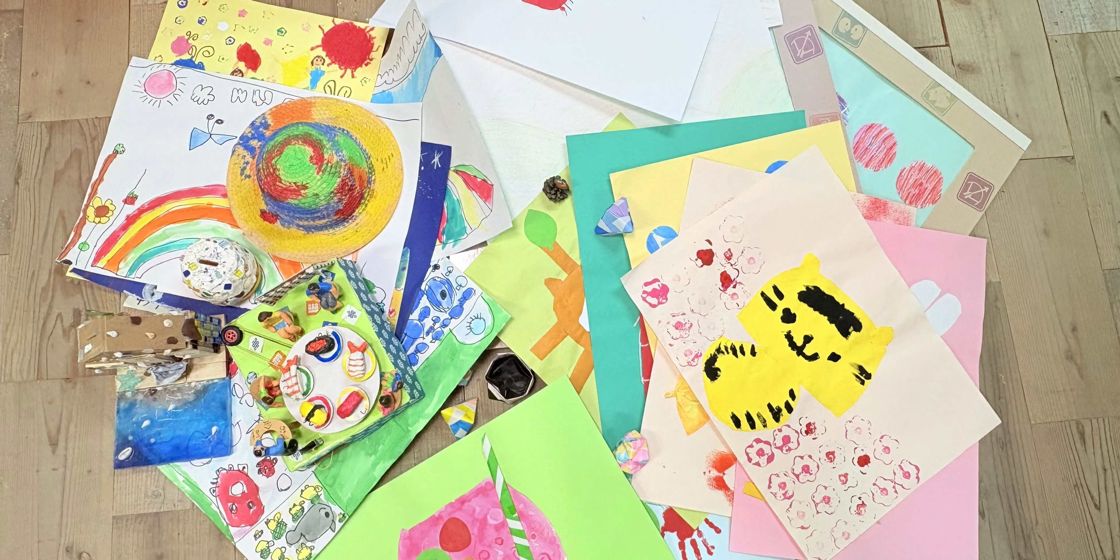 床いっぱいに広げられた、たくさんの子どもの絵や工作